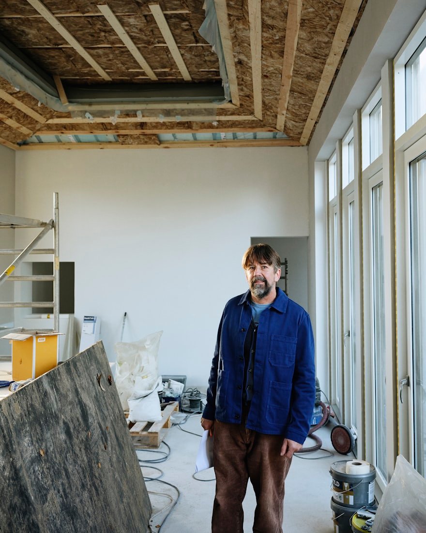 Dachdeckermeister in blauer Arbeitsjacke in der Holzwerkstatt
